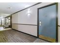 Hallway with carpet and wall lighting leading to an apartment entrance, plus a seating area at 460 S Marion Pkwy # 453, Denver, CO 80209