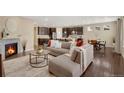 Open-concept living area with a fireplace, hardwood floors, and seamless flow to kitchen and dining space at 9772 Taylor River Cir, Littleton, CO 80125