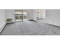 Spacious living room offers a sliding glass door and comfortable gray carpeting at 9655 E Center Ave # 9D, Denver, CO 80247