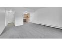 Open-concept living area with gray carpet flowing into the adjacent kitchen at 9655 E Center Ave # 9D, Denver, CO 80247