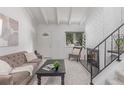 Bright living room with white brick fireplace, plush sofa, and cozy decor, next to the stairway at 1005 S Miller Way, Lakewood, CO 80226