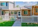 Inviting townhome featuring a cozy, fenced front yard and well-kept lawn at 703 S Depew St, Lakewood, CO 80226