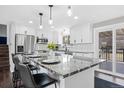 This updated kitchen features white cabinetry, granite countertops, stainless appliances, and a breakfast bar at 412 Gemini Ct, Lone Tree, CO 80124