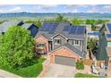 Elevated view featuring the home with solar panels, landscaping, mountain views, and neighborhood at 9821 Bucknell Ct, Highlands Ranch, CO 80129