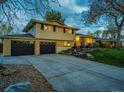 Charming two-story home with a well-manicured lawn, mature tree, and a two car garage at 1140 S Dover St, Lakewood, CO 80232