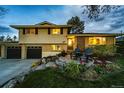 Charming two-story home with patio, chairs, landscaping and a two-car garage at 1140 S Dover St, Lakewood, CO 80232