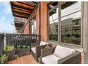 Outdoor balcony with lounge seating, brick exterior and views of the neighboring building at 2960 Inca St # 317, Denver, CO 80202
