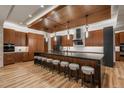 A gourmet kitchen features an expansive island with seating and hardwood floors at 5140 S Kearney Ct, Greenwood Village, CO 80111