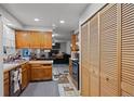 Functional kitchen with wooden cabinets, an oven, and adjacent access to the living room at 4550 E 121St Pl, Thornton, CO 80241