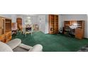 Cozy living room featuring classic green carpeting and a sunlit dining area at 4550 E 121St Pl, Thornton, CO 80241
