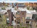 Aerial view of upscale townhomes featuring rooftop decks with outdoor seating and a fireplace, surrounded by lush trees at 8071 E 29Th Ave, Denver, CO 80238