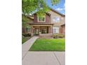 Charming brick townhouse with a covered front porch and well-maintained landscaping at 6404 Silver Mesa Dr # E, Highlands Ranch, CO 80130