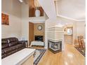 Open-concept living room with hardwood floors, fireplace, and seamless flow to the kitchen and dining area at 6404 Silver Mesa Dr # E, Highlands Ranch, CO 80130