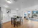 Modern kitchen featuring white cabinetry, stainless steel appliances, hardwood floors, and an island with seating at 1750 Wewatta St # 1501, Denver, CO 80202