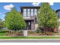 Elegant home showcasing lush greenery, manicured flower beds, and a unique gray brick exterior at 8565 E 50Th Dr, Denver, CO 80238