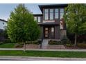 Contemporary home with a well-kept lawn, professional landscaping, and a striking gray brick design at 8565 E 50Th Dr, Denver, CO 80238