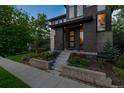 Attractive home featuring a charming front porch, colorful landscaping, and an eye-catching brick exterior at 8565 E 50Th Dr, Denver, CO 80238