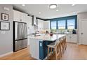 Modern white kitchen features stainless steel appliances, a large island with seating, and ample natural light at 15020 Cast Pebble Cir, Parker, CO 80134