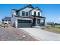 Two-story home boasts a gray and white exterior, attached two-car garage, and a cozy front porch at 1041 W Witherspoon Dr, Elizabeth, CO 80107