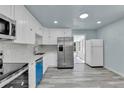Bright kitchen featuring white cabinets, stainless steel appliances and modern countertops at 1500 S Wolcott Ct, Denver, CO 80219
