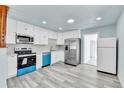 Bright kitchen featuring white cabinets, stainless steel appliances and modern countertops at 1500 S Wolcott Ct, Denver, CO 80219