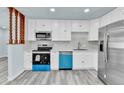 Bright kitchen featuring white cabinets, stainless steel appliances and modern countertops at 1500 S Wolcott Ct, Denver, CO 80219