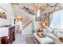 Inviting living room featuring a vaulted ceiling, wall decor, plush seating, and access to a dining area at 4969 Thorndike Ave, Castle Rock, CO 80104