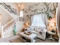 Comfortable living room featuring neutral colors, vaulted ceiling, large windows, decorative vines, and stylish furnishings at 4969 Thorndike Ave, Castle Rock, CO 80104