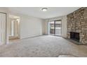 Bright living room with a stone fireplace and sliding glass doors to the outdoor patio at 331 Wright St # 108, Lakewood, CO 80228