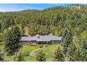 Beautiful ranch-style home in a serene, wooded setting with a spacious backyard and deck at 27436 Kennedy Gulch Rd, Conifer, CO 80433