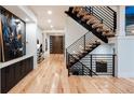 Bright entryway featuring hardwood floors, modern staircase with metal railings, and a designer front door at 2495 Red Hawk Pl, Broomfield, CO 80023