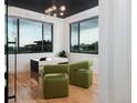 Modern office with a black ceiling, sleek desk, two green chairs, and large windows overlooking the property at 2495 Red Hawk Pl, Broomfield, CO 80023