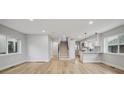 Spacious open-concept living space with hardwood floors leading to the kitchen and staircase at 3908 Mariposa St, Denver, CO 80211