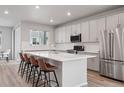 Bright kitchen with white cabinets, quartz countertops, and stainless steel appliances at 12283 W 57Th Ln, Arvada, CO 80002