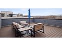 Inviting rooftop deck with cozy seating, an umbrella, and scenic views for relaxing and entertaining guests at 12283 W 57Th Ln, Arvada, CO 80002