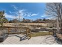 The wood deck overlooks a well-maintained lawn and garden area, with a view of neighboring houses beyond a wooden fence at 10472 Grizzly Gulch, Highlands Ranch, CO 80129