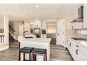 Spacious, open-concept kitchen featuring stainless steel appliances, white cabinets, an island with seating, and modern lighting at 10472 Grizzly Gulch, Highlands Ranch, CO 80129