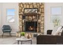 Close-up of the stone fireplace, complete with decorative mantel and metal fire screen at 14475 Lanewood St, Brighton, CO 80603