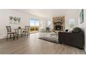 Bright living room with a stone fireplace, wood floors, and access to an outdoor deck at 14475 Lanewood St, Brighton, CO 80603