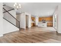 Bright, open-concept living room with hardwood floors, staircase, and kitchen in a modern home at 39731 Congress Ln, Elizabeth, CO 80107