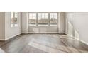 Bright living room featuring hardwood floors and three large windows at 39731 Congress Ln, Elizabeth, CO 80107