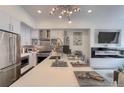 Modern kitchen featuring stainless steel appliances, a large island with seating, and an eye-catching chandelier at 3030 Wilson Ct # 5, Denver, CO 80205