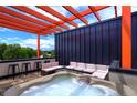 Inviting rooftop deck with a hot tub, comfortable seating, and a vibrant orange pergola at 3030 Wilson Ct # 5, Denver, CO 80205