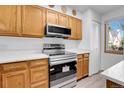 Kitchen with stainless steel appliances, light wood cabinets, and white countertops at 9320 W Ontario Dr, Littleton, CO 80128