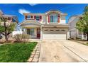 Charming two-story home featuring red shutters, a well-maintained lawn, and a spacious two car garage at 5570 Perth Ct, Denver, CO 80249