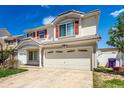 Charming two-story home featuring red shutters, a well-maintained lawn, and a spacious two car garage at 5570 Perth Ct, Denver, CO 80249