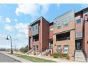 Modern multi-story townhomes showcasing brick and siding exteriors with balconies and well-maintained landscaping at 5471 W 97Th Pl # E, Broomfield, CO 80020