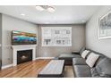 Comfortable living room featuring a fireplace, large windows, hardwood floors, and a modern sectional sofa at 5471 W 97Th Pl # E, Broomfield, CO 80020