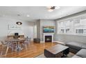 Open-concept living room with hardwood floors, a fireplace, a modern lighting fixture, and comfortable seating at 5471 W 97Th Pl # E, Broomfield, CO 80020