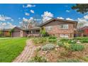 Beautiful brick home with manicured garden and a brick pathway leading to the entrance at 55 S Flower St, Lakewood, CO 80226